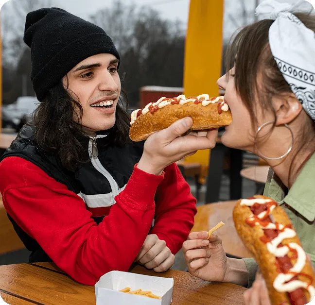 Friends sharing hot dogs